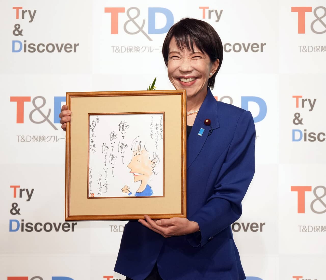 授賞式に出席し、やくみつる氏の絵を贈られた高市早苗首相